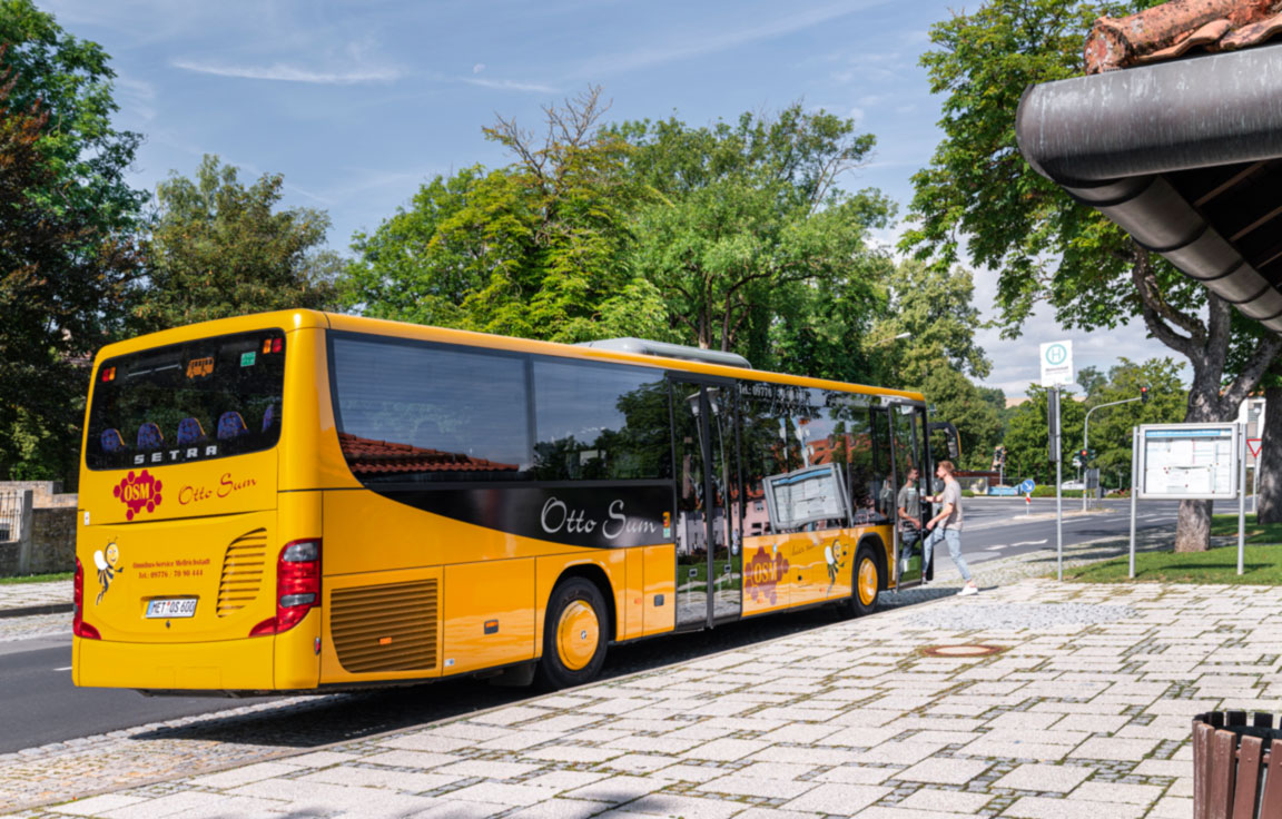 Fahrgäste steigen an der Haltestelle in den Linienbus